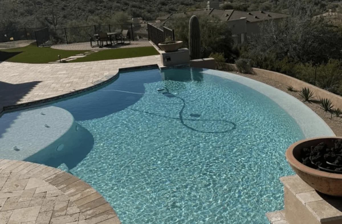 A free-form desert pool with travertine decking and saguaro cactus in the Mesa, Arizona area